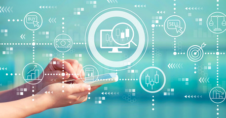 Stock trading concept with person holding a white smartphone