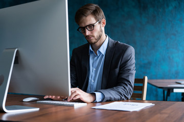 Man Working At Computer In Contemporary Office.