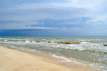 Sea waves wash the clean sandy beach. Landscape on a wild beach. Sea storm.