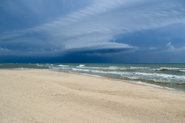 Fototapeta na wymiar Sea waves wash the clean sandy beach. Landscape on a wild beach. Sea storm.