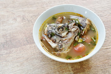 spicy boiled Tilapia head fish in tom yum soup on bowl