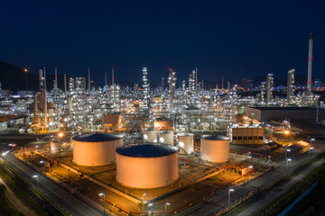 Aerial view. Oil refinery factory and oil storage tank at twilight and night. Petrochemical...