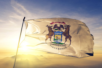 Michigan Governor flag waving on the top sunrise mist fog