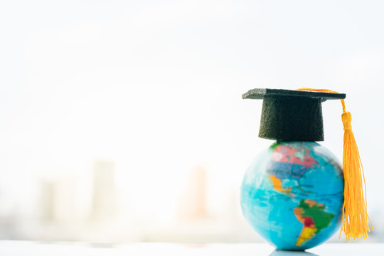 Study abroad international and Back to School Concept. Graduation hat on top Earth globe model map with city background using as congratulations to graduates, Studies lead to success in world wide.