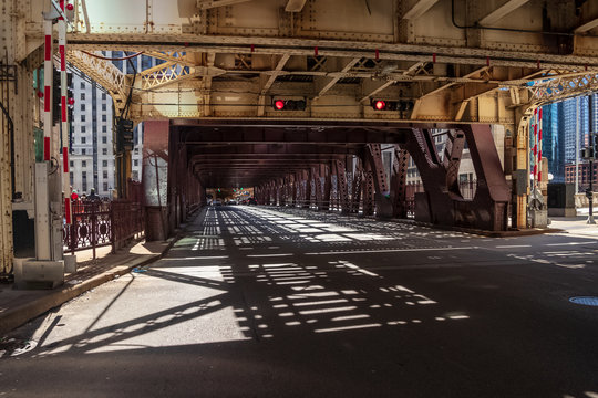Shadows from an overhead el train are cast onto Wells Street at a red light