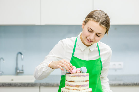 Pastry cook makes a wedding cake with macarons