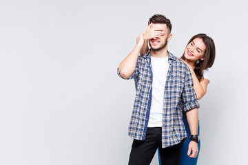 Portrait of young friends couple, she closed his eyes, they are standing at white background. Copy space.