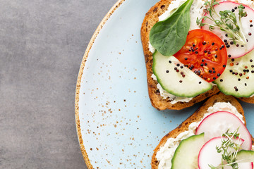 Sandwich with cereals bread and salami on dark marble background.