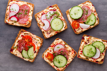 Sandwiches with cream cheese, vegetables and salami.