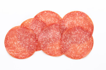 Salami slices on white background.
