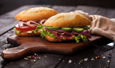 Fresh burgers on wooden table and dark background