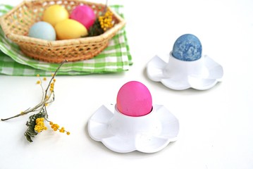 Multi-colored Easter eggs in stands on a white background. Easter concept.