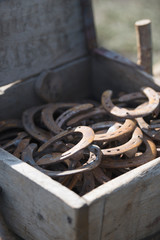 Rusty metal horseshoes in the old wooden box, lucky charm, talisman, handicraft