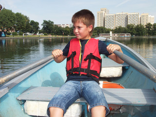 Boy riding on a boat in summer