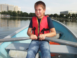Boy riding on a boat in summer