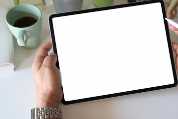 Cropped shot of businessman holding blank screen tablet in office