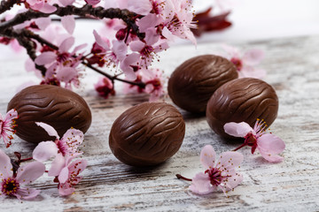 Uova di Pasqua su tavolo con fiori rosa