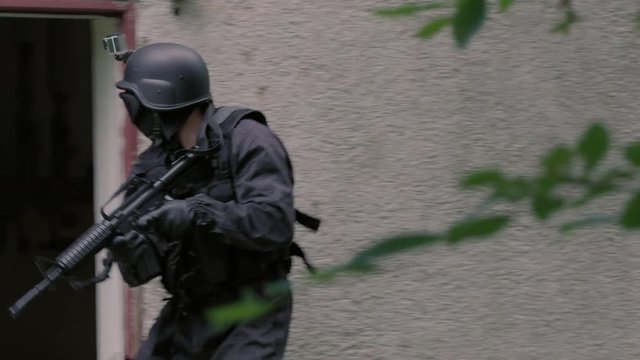Specila Force Team walk along a rustical house and they enter it.