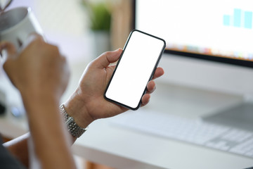 Business man showing blank screen mobile phone in office