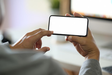 Man hands holding blank screen mobile smartphone in office