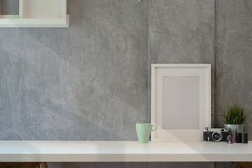 Mockup poster with vantage camera on white wooden desk space and copy space.