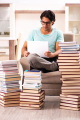 Male student with many books at home 