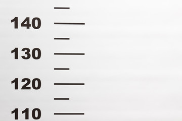 Photo background criminal police mugshot, used to determine height when photographing a detainee, suspect or convict. White background with printed numbers to measure human height. Copy space
