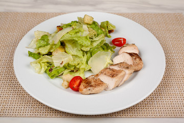 Stewed chicken fillet with tomato and cabbage salad.