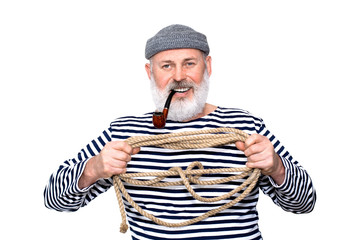 Photo portrait of a cheerful sailor with his pipe and gray beard, holding a rope