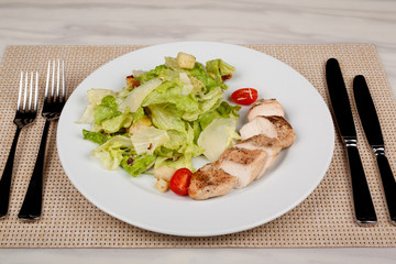 Stewed chicken fillet with tomato and cabbage salad.