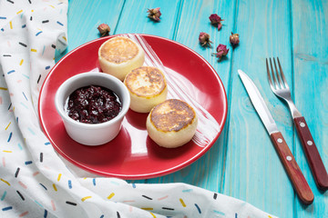 Cottage cheese pancakes on wooden background. Syrniki with jam. Homemade food