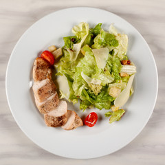 Stewed chicken fillet with tomato and cabbage salad.