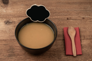 Soup and empty chalkboard on a wooden table