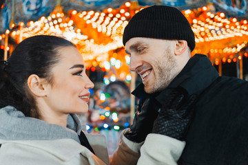 Man and woman at christmas fair looking at each other and smiling. Selfie