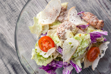 Close-up of a classic Caesar salad with chicken, iceberg lettuce, croutons, tomatoes, Chinese cabbage. Concept professional food shooting, photo session of the new menu