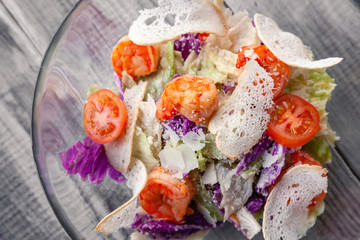 Close-up of a classic Caesar salad with grilled shrimps, iceberg lettuce, croutons, tomatoes, Chinese cabbage. Concept professional food shooting, photo session of the new menu