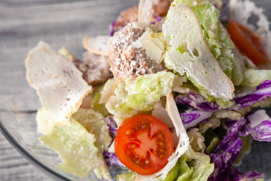 Close-up of a classic Caesar salad with chicken, iceberg lettuce, croutons, tomatoes, Chinese cabbage. Concept professional food shooting, photo session of the new menu