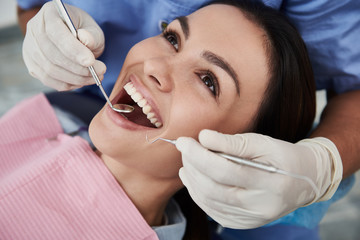 Charming young lady being examined by doctor at dental clinic