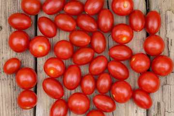  Fresh mini organic tomatoes on old wooden table.