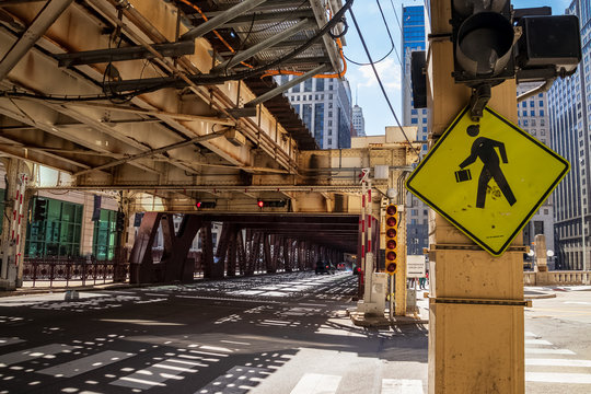 Wells Street view of pedestrian crossing amongst shadows cast from overhead elevated train tracks