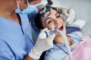 Beautiful young woman having dental procedure at clinic
