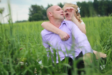 Couple lovers walking in field in summer day