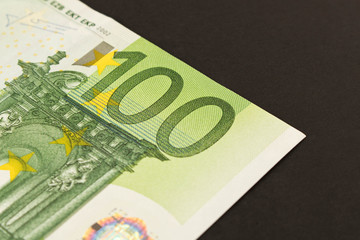 100 Euro banknote on a dark background. Close up. The concept of savings.