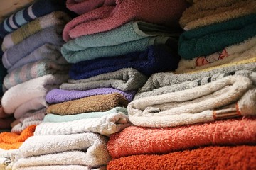 close up of different colorful towels in a shelve