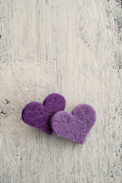 purple hearts on a wooden background with copy space