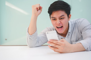 Close up young asian hipster man raising hand with feeling success and happy after become winner in...