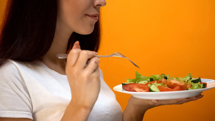 Female eating vegetable salad, vegetarian lifestyle, healthy diet for slimming