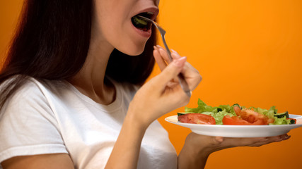 Girl eating cucumber and vegetables, healthy diet for weight loss, vitamins