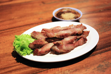 Charcoal-boiled pork neck, Northeastern Thai style grilled pork. Grilled barbecue pork Thai traditional style with spicy dipping sauce.