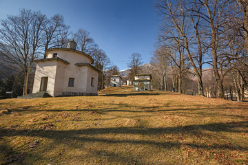 Obraz premium Panoramic view in the afternoon light on a winter day, of the seventeenth-century chapels of the monumental complex dedicated to the Virgin Mary, of the Sanctuary of Oropa in Piedmont, Italy.